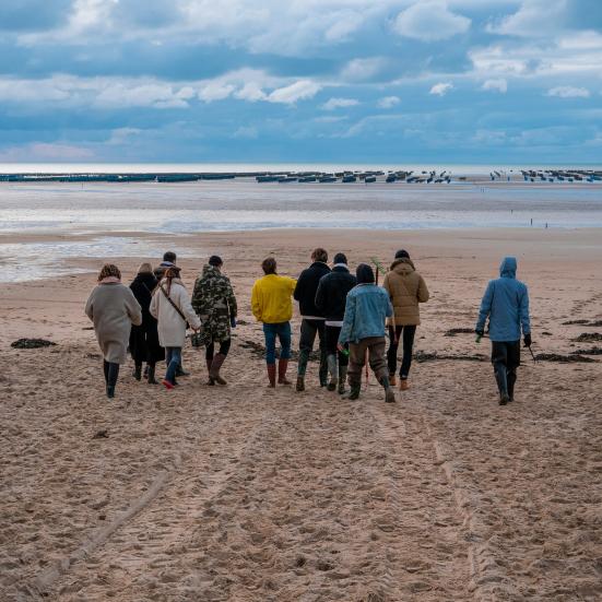 En gruppe mennesker, der går ved havet