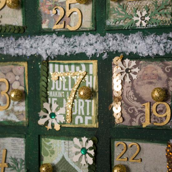 Nærbillede af en grøn julekalender med låger