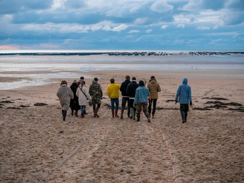 En gruppe mennesker, der går ved havet