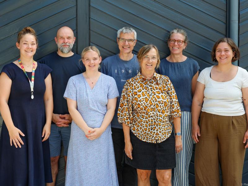 Billede af bibliotekspersonalet foran en sortmalet facade