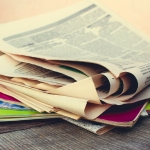 en stak aviser og tidsskrifter på et bord