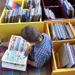 dreng der sidder på biblioteket og læser