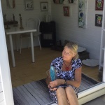 Ellen Engsig siddende i døren til sit galleri