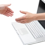 en hånd der rækker ud af en computer for at hilse på en anden hånd
