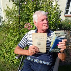 portræt af Peter Dragsbo med tre bøger i hånden