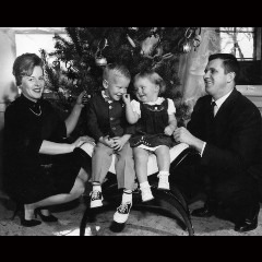 et gammelt sort/hvidt billede af en familie foran et juletræ