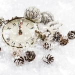 et ur der ligger i sne med forskelligt pynt rundt om